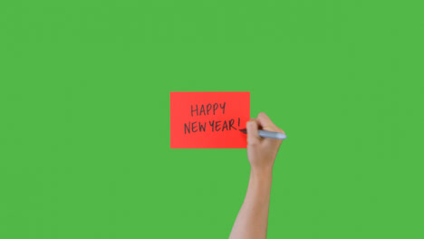 Woman-Writing-Happy-New-Year-on-Paper-with-Green-Screen-02